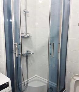 a shower with a glass door in a bathroom at Tbilisi City Center Flat in Itʼkhvisi