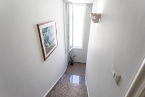 un pasillo con una pintura en la pared y una ventana en Dimora Mini Coccola - Salento Reservation, en Ugento