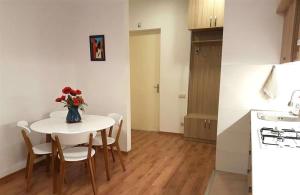 a kitchen with a table with a vase of flowers on it at Tbilisi City Center Flat in Itʼkhvisi