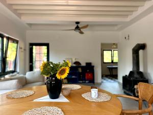 a wooden table with a vase of flowers on top of it at Dock Cottage House in Bădeni