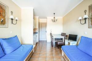 salon z dwiema niebieskimi kanapami i stołem w obiekcie Les Appartements aux Restanques du Golfe de St Tropez - maeva Home - Appartement 2 Pièces 4 Personnes - Confort MAE-3354 w mieście Grimaud