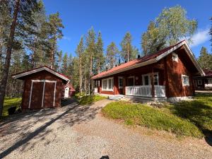 a cabin in the woods with a gravel driveway at Metsäkimara in Kittilä