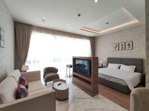 a bedroom with a bed and a couch and a tv at 5 Star Luxury Flat in Leela Residence in Bengaluru