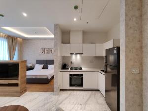 a kitchen with a refrigerator and a bed in a room at 5 Star Luxury Flat in Leela Residence in Bengaluru