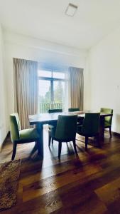 Un comedor con mesa y sillas y una ventana. en THE - CR7 - Manchester Grand apartment, en Nuwara Eliya