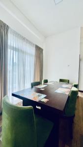 Una sala de conferencias con una mesa y sillas verdes. en THE - CR7 - Manchester Grand apartment, en Nuwara Eliya