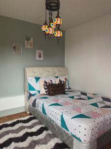 a bedroom with a bed and a chandelier at Casa de Descanso in Kiawagan