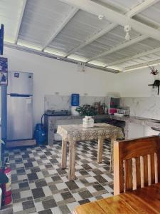 a kitchen with a table and a refrigerator at Casa de Descanso in Kiawagan