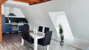 a dining room with a table and black chairs at Ferien- Monteurwohnung in Bielefeld