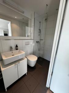 a bathroom with a sink and a toilet and a shower at Süße Wohnung im Herzen von Köln! in Cologne