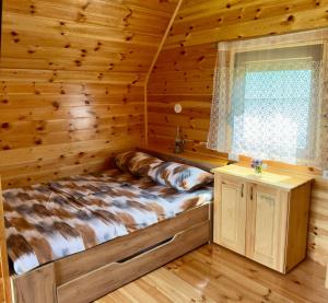 a bed in a log cabin with a window at Etno Niko in Žabljak