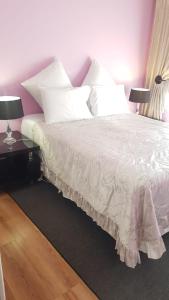 a bedroom with a bed with white sheets and pillows at Dali in Pretoria
