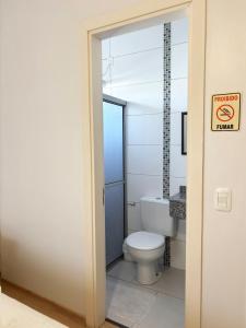 a bathroom with a toilet and a no smoking sign at Pousada Dona Luiza in Carlos Barbosa +11 photos
