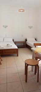 a room with two beds and a table and chairs at House Maria Manolaki, 1st Floor Studios in Vourvourou