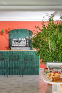a green bar with stools in front of a kitchen at Hotel Villa Ireos in Casamicciola Terme