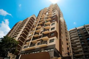 a tall apartment building in front of a blue sky at Essential comfort - Vila Mariana in São Paulo