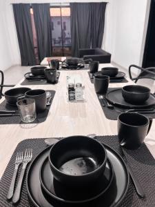 a table with black plates and utensils on it at Casa con piscina y quincho in Candelaria