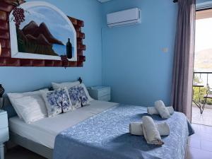 a blue bedroom with a bed with towels on it at Mina Apartments in Poros +73 photos