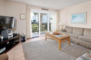 a living room with a couch and a coffee table at Beach Club #118 in Saint Simons Island