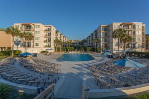 a resort with a pool and chairs and buildings at Beach Club #118 in Saint Simons Island