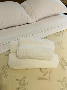 a pile of towels sitting on top of a bed at Otima localizacao metro Sacoma Aeroporto Congonhas Av Paulista Great location 80m subway near Av Paulista and Congonhas Airport Smart TV 50 free channels 600gb WiFi Pool Gym in Sao Paulo +14 photos