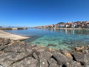 a view of a beach with rocks in the water at Apartamento Solpor in A Guarda