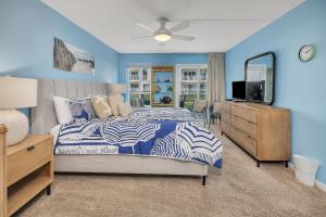 a bedroom with a bed and a dresser and a mirror at Beach Club #127 in Saint Simons Island +31 photos