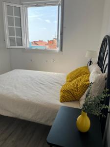 a bedroom with a bed with a window and a table at Apartamento Solpor in A Guarda