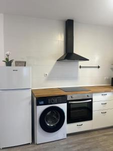 a kitchen with a washing machine and a refrigerator at Apartamento Solpor in A Guarda