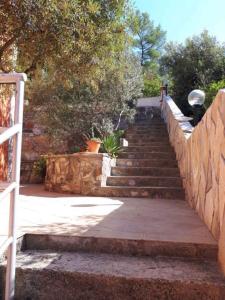 a set of stairs leading up to a stone wall at Apartment in Brna - Insel Korcula 6397 in Brna +9 photos