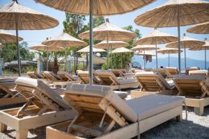 a bunch of chairs and umbrellas on a beach at White Hill by Fllad e Vale in Vlorë