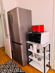 a kitchen with a refrigerator and a microwave at Linden Alley Retreat Sarajevo with free parking in Sarajevo