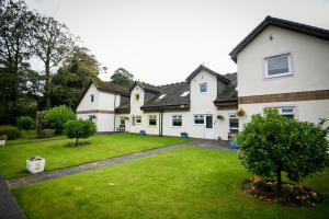 a large white house with a green yard at Cunninghame 4 in Beith