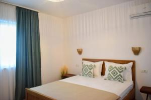 a bedroom with a bed and a window at Pensiunea Pera in Jurilovca