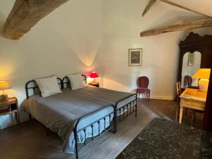 a bedroom with a bed and a table and a chair at Gîte La Maison des Poètes de 1 à 6 personnes à Treigny Perreuse in Perreuse