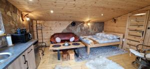 a room with a couch and a table in a cabin at Babiogórskie Domki in Lipnica Wielka