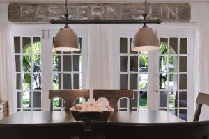 a dining room with a table and chairs and windows at Off The Charts-Waterfront Tiki Bar & Private Dock in Islamorada