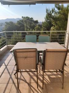 a table and chairs on a balcony with a view at Rafina suits in Rafina