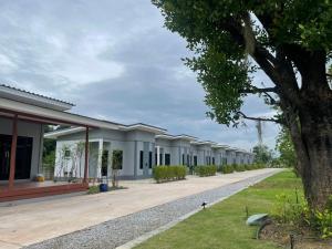 a row of buildings with a tree in the foreground at กลางนา รีสอร์ท in Thang Kwian