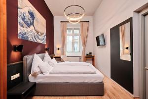 a bedroom with a bed in a room with red walls at Karl - das City Hotel Konstanz in Konstanz