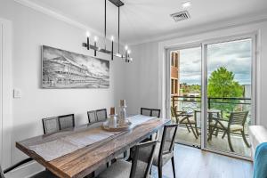 a dining room with a wooden table and a balcony at Q Club Suite - Saratoga Adelphi Hotel in Saratoga Springs