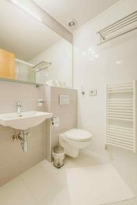a white bathroom with a toilet and a sink at Guest House Neho in Cres