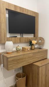 a flat screen tv on top of a wooden shelf at Casa Tapada do Bento II- Albufeira in Albufeira