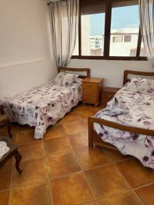 a bedroom with two beds and a window at Les dunes de martil familles in Martil +38 photos
