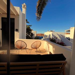 two chairs on a balcony with a view of the ocean at Pegasus & Perseas Serifos Houses in Serifos Chora