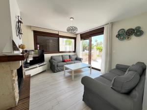 a living room with a couch and a tv at PUSHE Village Playa Granada Beach & Golf 3 in Motril