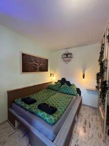 ein Schlafzimmer mit einem Bett mit grüner Bettdecke in der Unterkunft Chill Home in Klagenfurt am Wörthersee