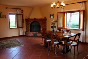 a dining room with a table and chairs and a fireplace at Podere Campanella in Sinalunga
