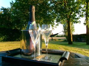 a table with two glasses and a bottle of wine at Kraaiberg in Ploegsteert