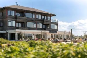 斯希蒙尼克奥赫Noderstraun 40的一座房子,前面有坐在桌子上的人